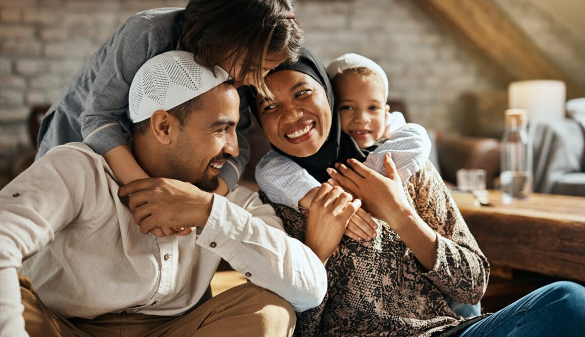 Happy Muslim kids embracing their parents and having fun at home. Happy Muslim parents having fun with their children who are embracing them at home.